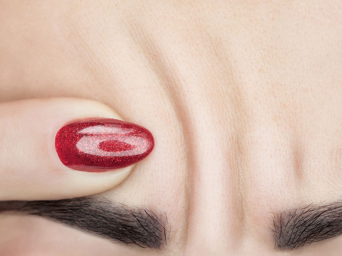 Close-up of hand with red glitter nails.
