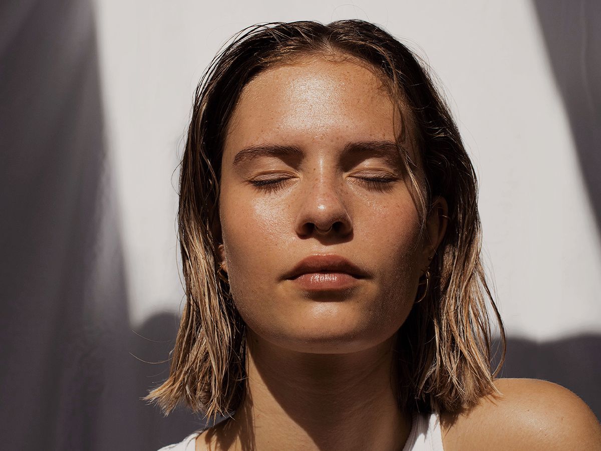 Person with closed eyes basking in sunlight.