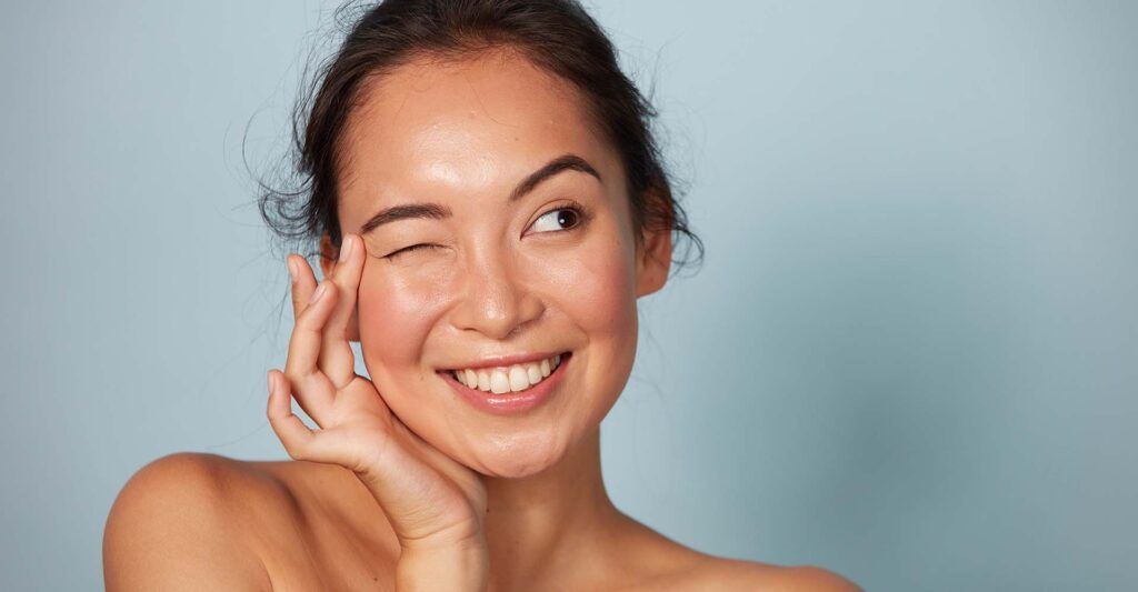 Smiling woman winking with playful expression.