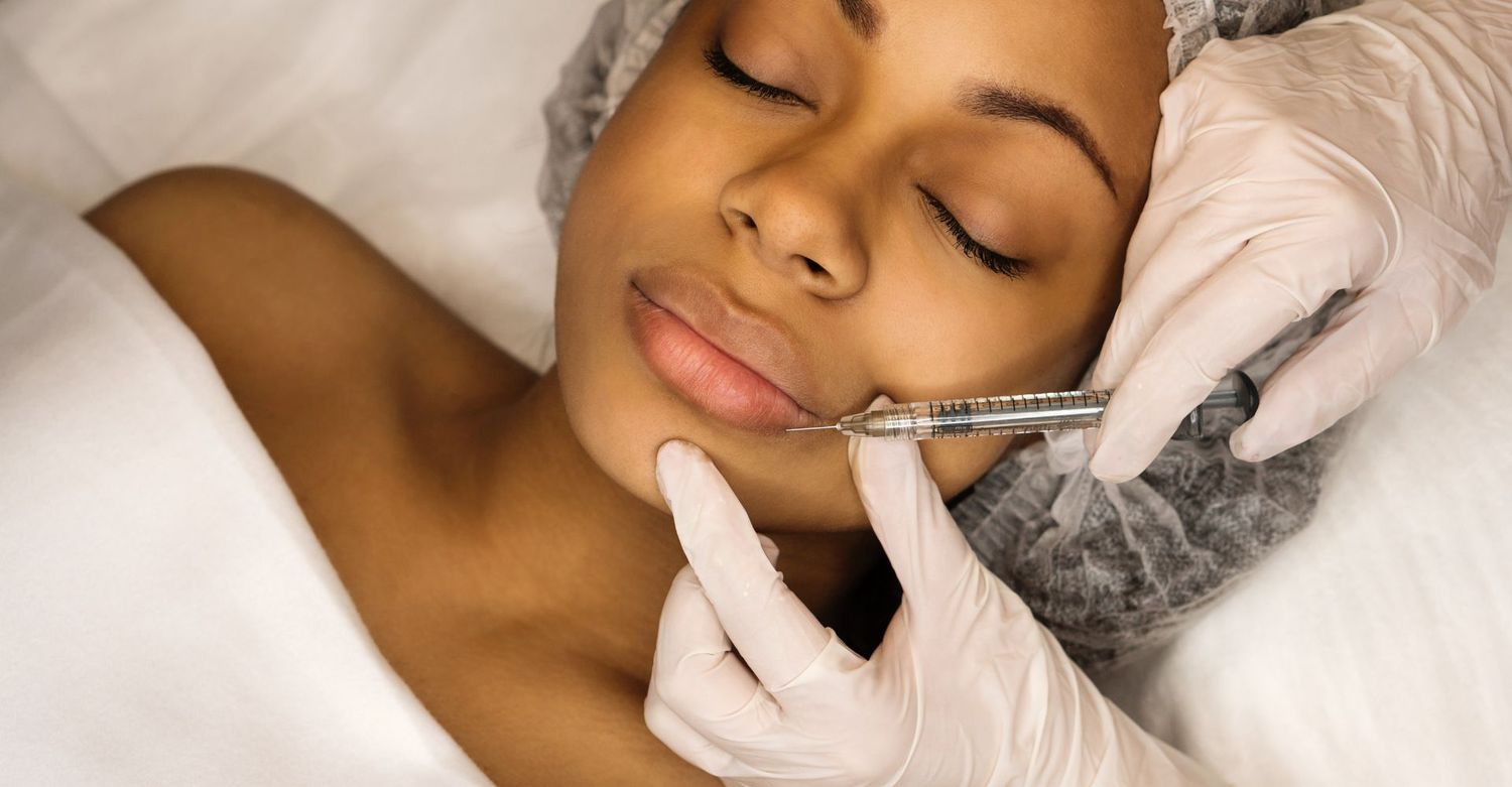 Woman receiving cosmetic lip injection treatment.