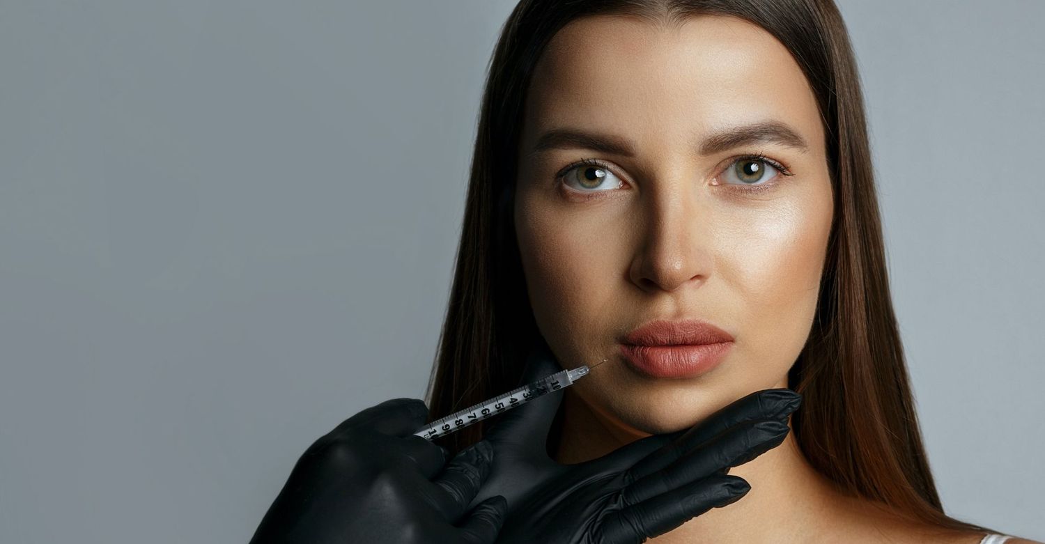 Woman receiving a cosmetic injection for fuller lips.