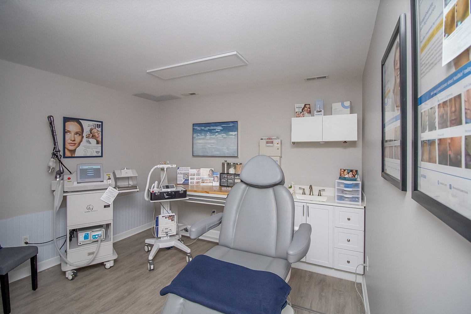 Medical aesthetic treatment room with equipment and chair.