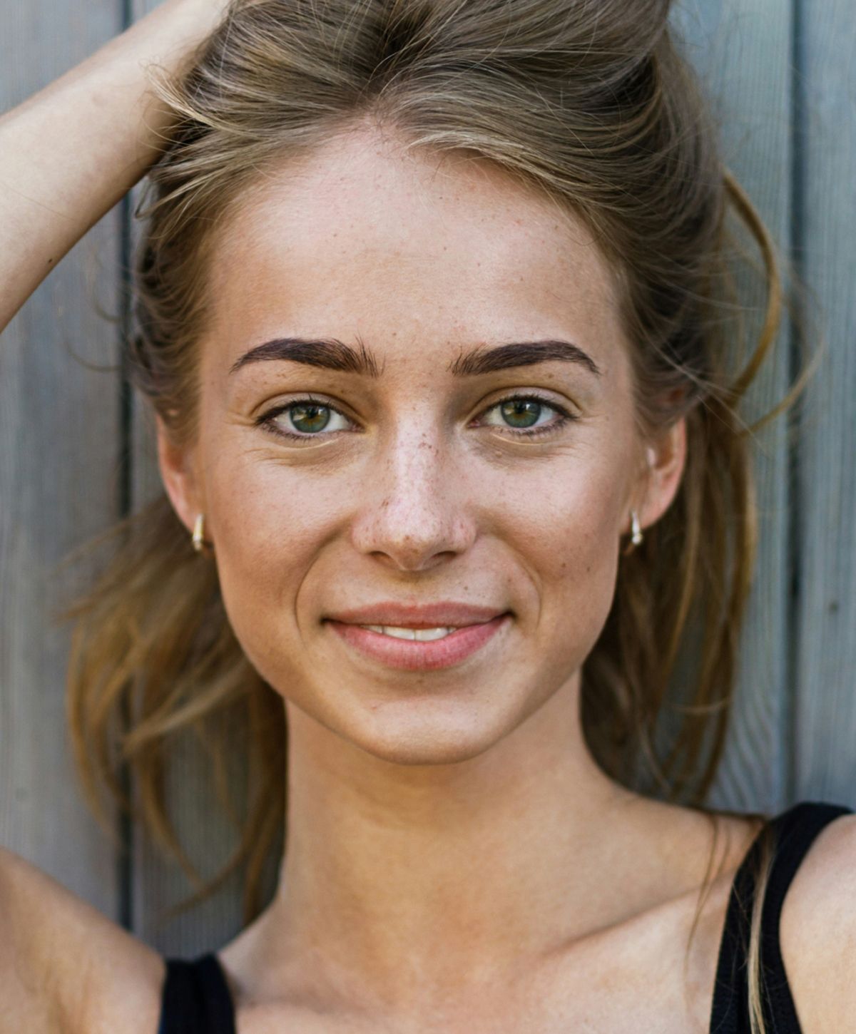Young woman with thoughtful expression and hand on chin.