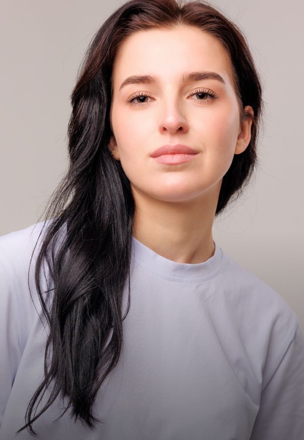Young woman with long, wavy hair smiling gently.