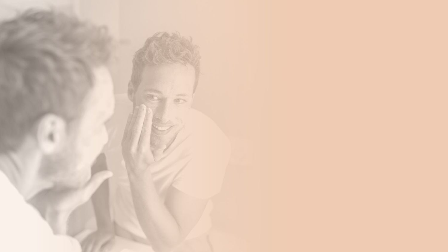 Man applying skincare in front of a mirror.