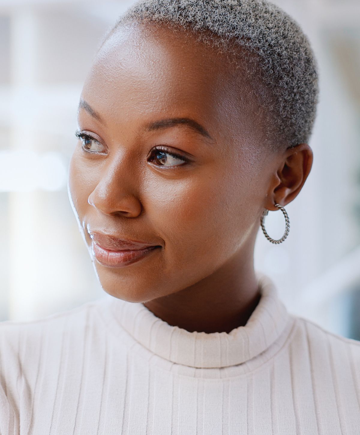 Woman with short hair and hoop earrings.