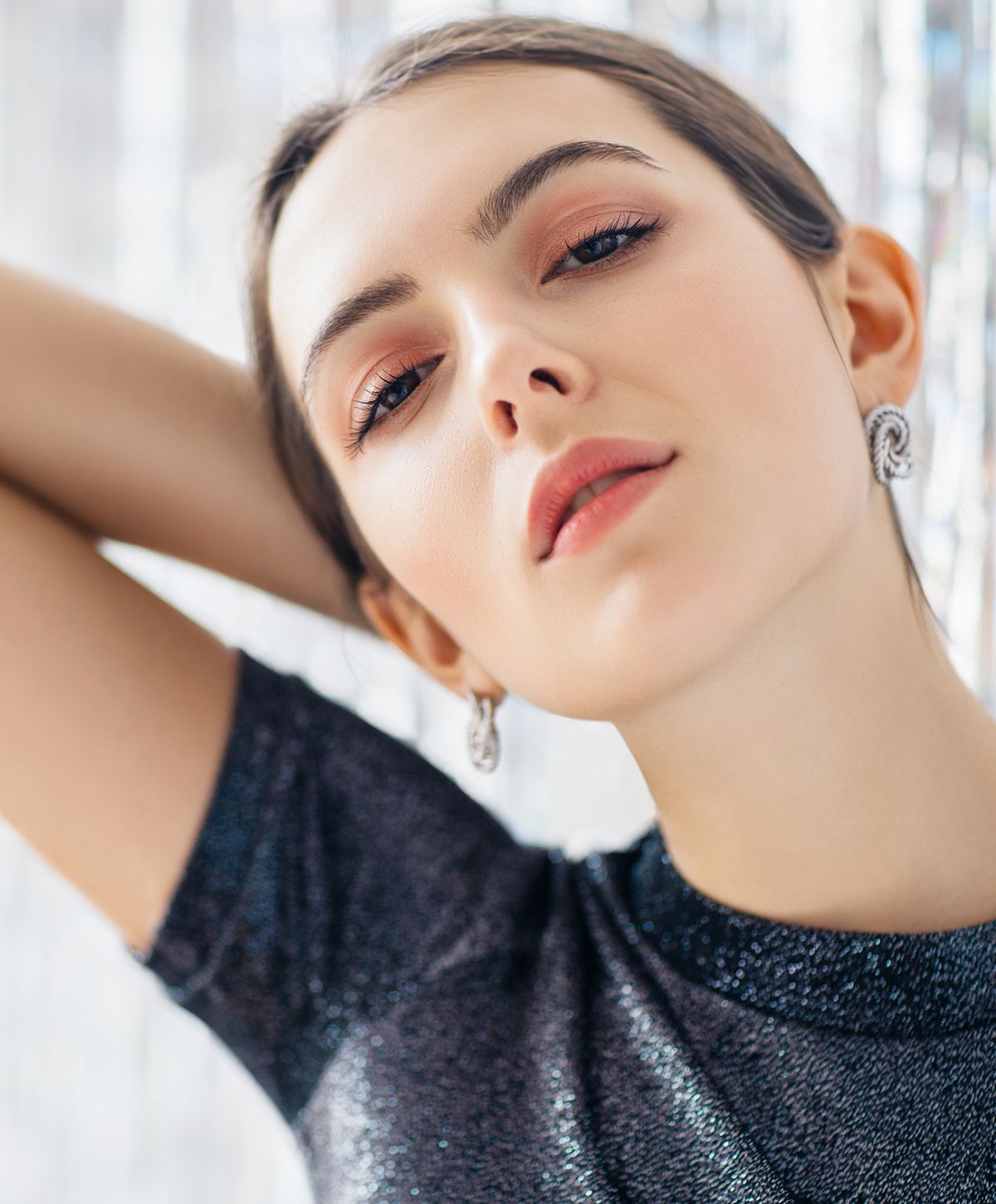 Model posing elegantly with sparkling earrings.