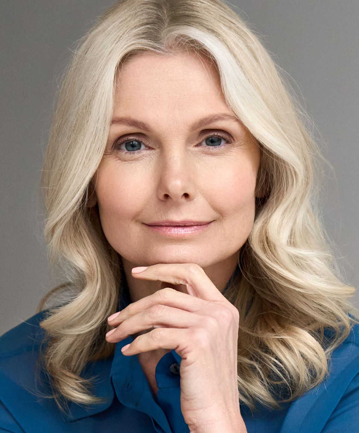 Woman with wavy blonde hair and thoughtful expression.