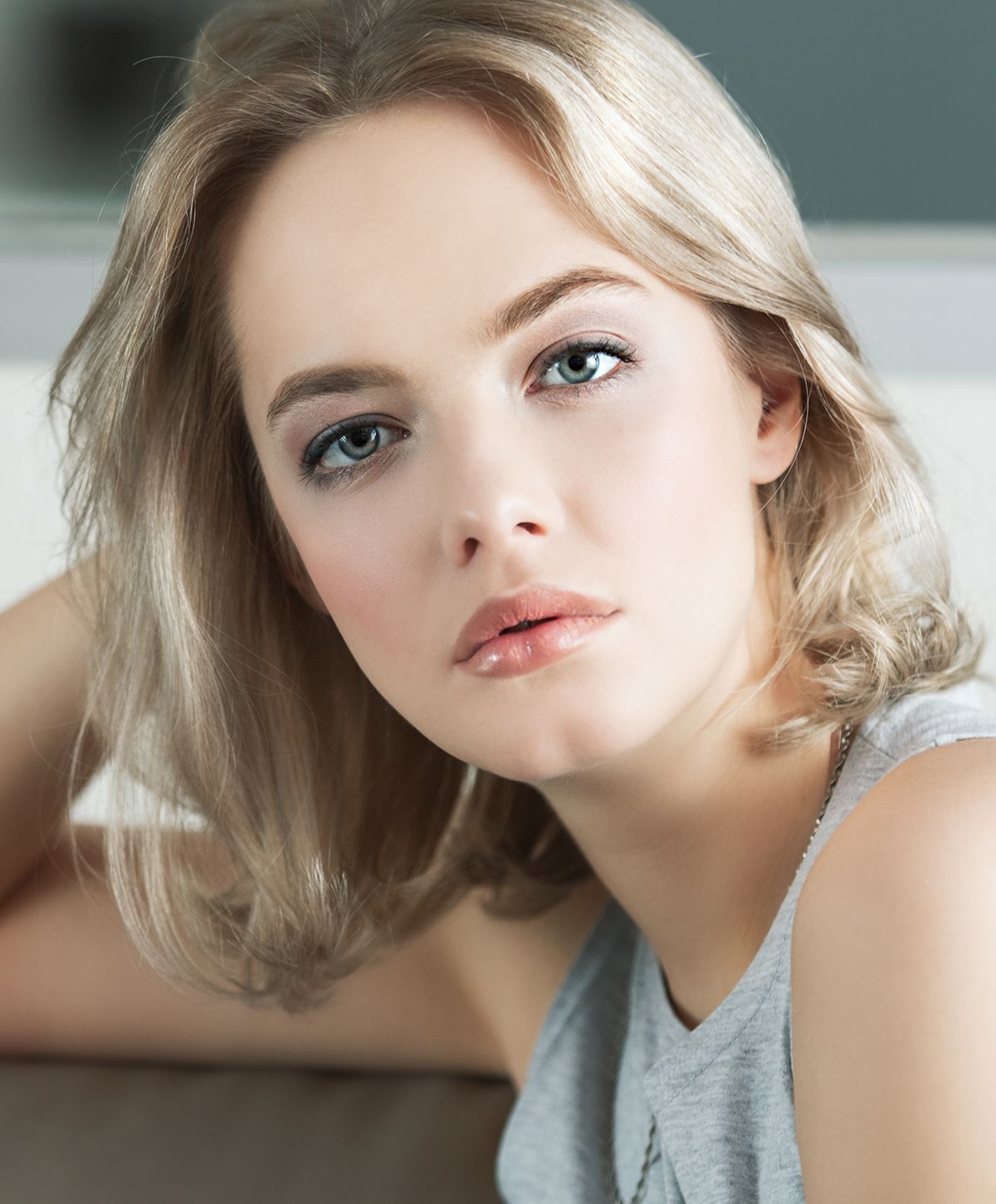 Suffolk benign mole removal model with soft makeup, relaxed pose.