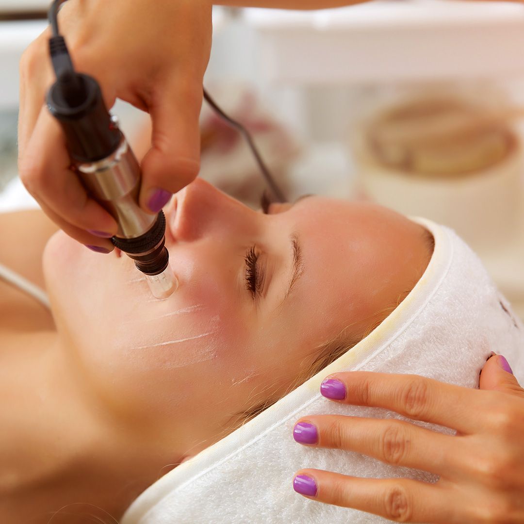 Facial treatment with microneedling device in spa.