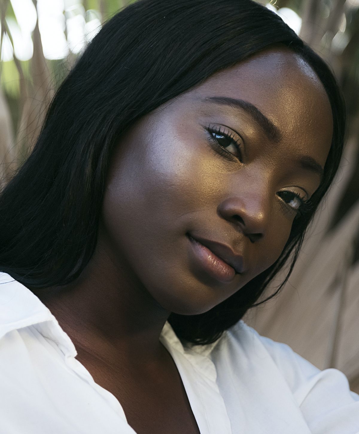 Young woman with long, wavy hair smiling gently.