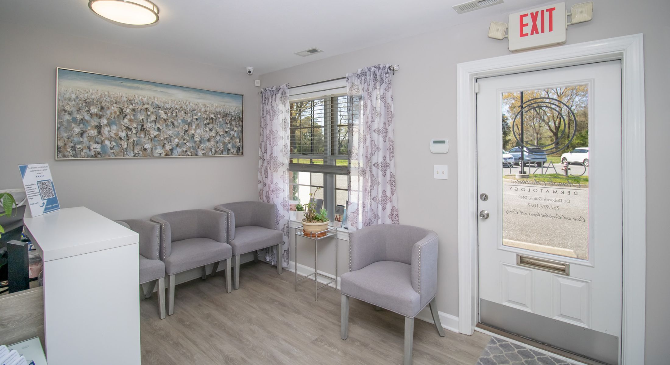 Modern waiting room with gray chairs and artwork.