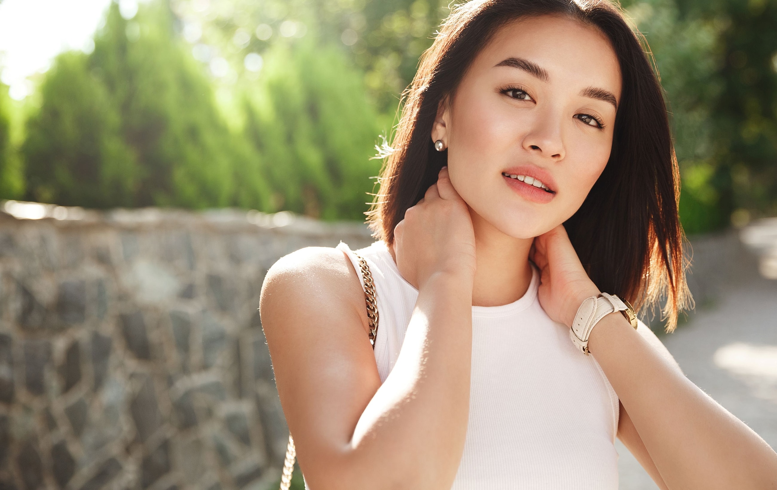 Woman with smooth youthful neck and skin outdoors representing non-surgical treatment options for tech neck and crepey neck skin