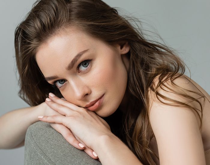 Woman with long hair resting on hands.