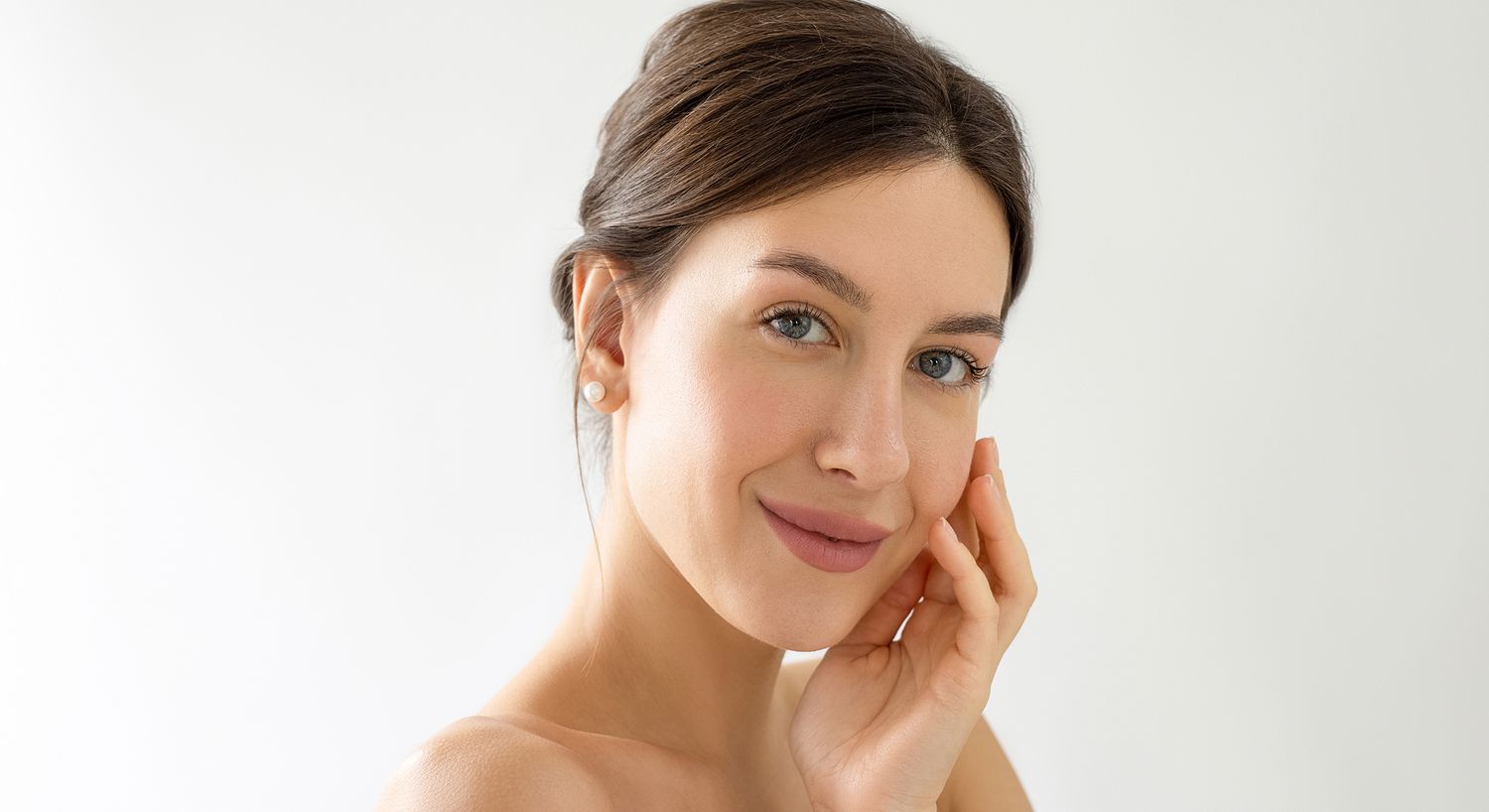 Smiling woman touching her face softly.