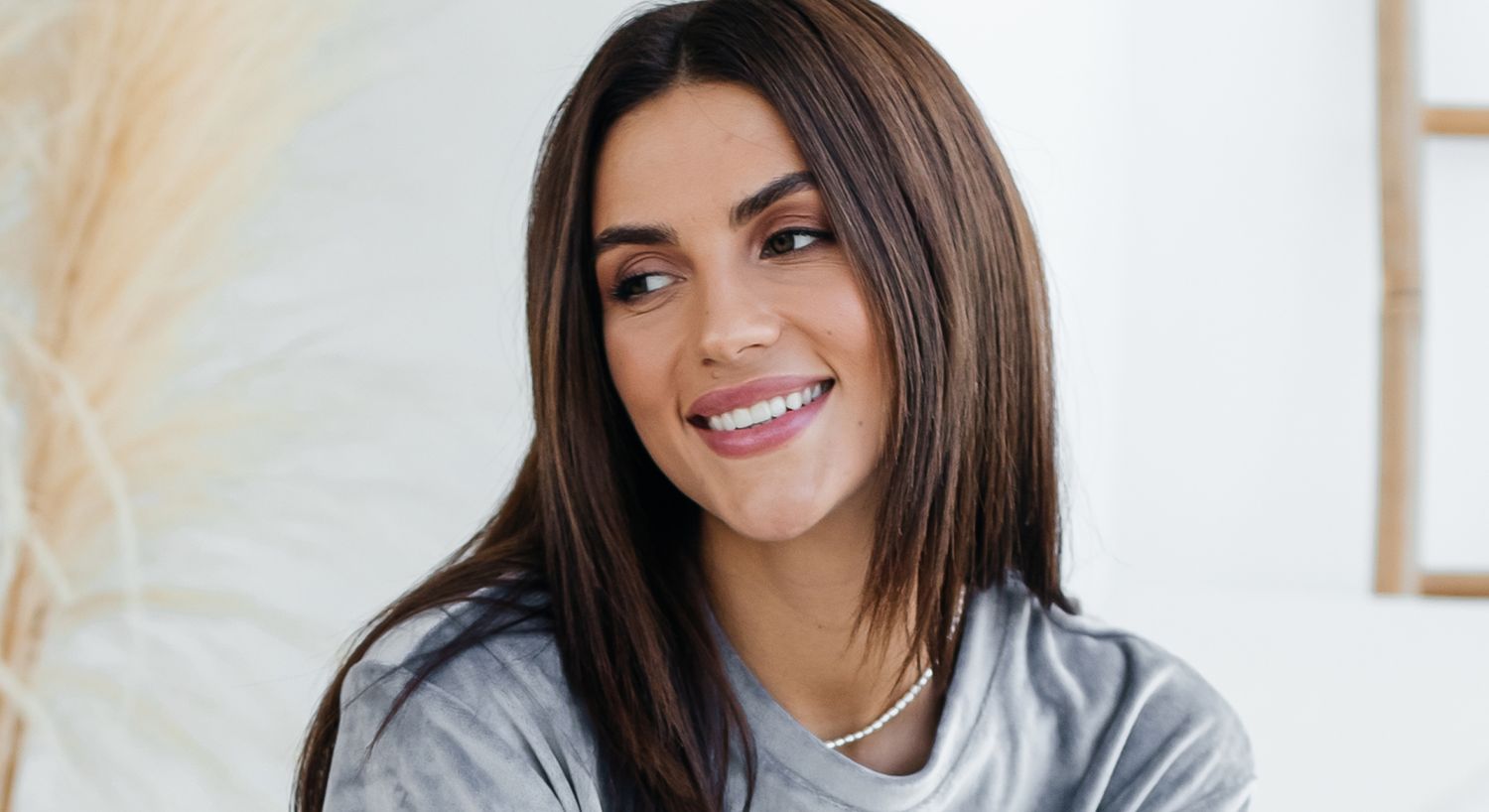 Smiling woman with long hair and relaxed expression.