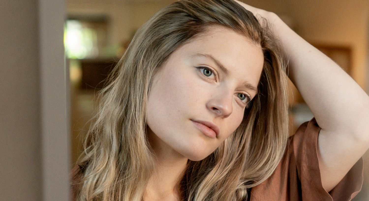 Young woman with long hair, thoughtful expression.